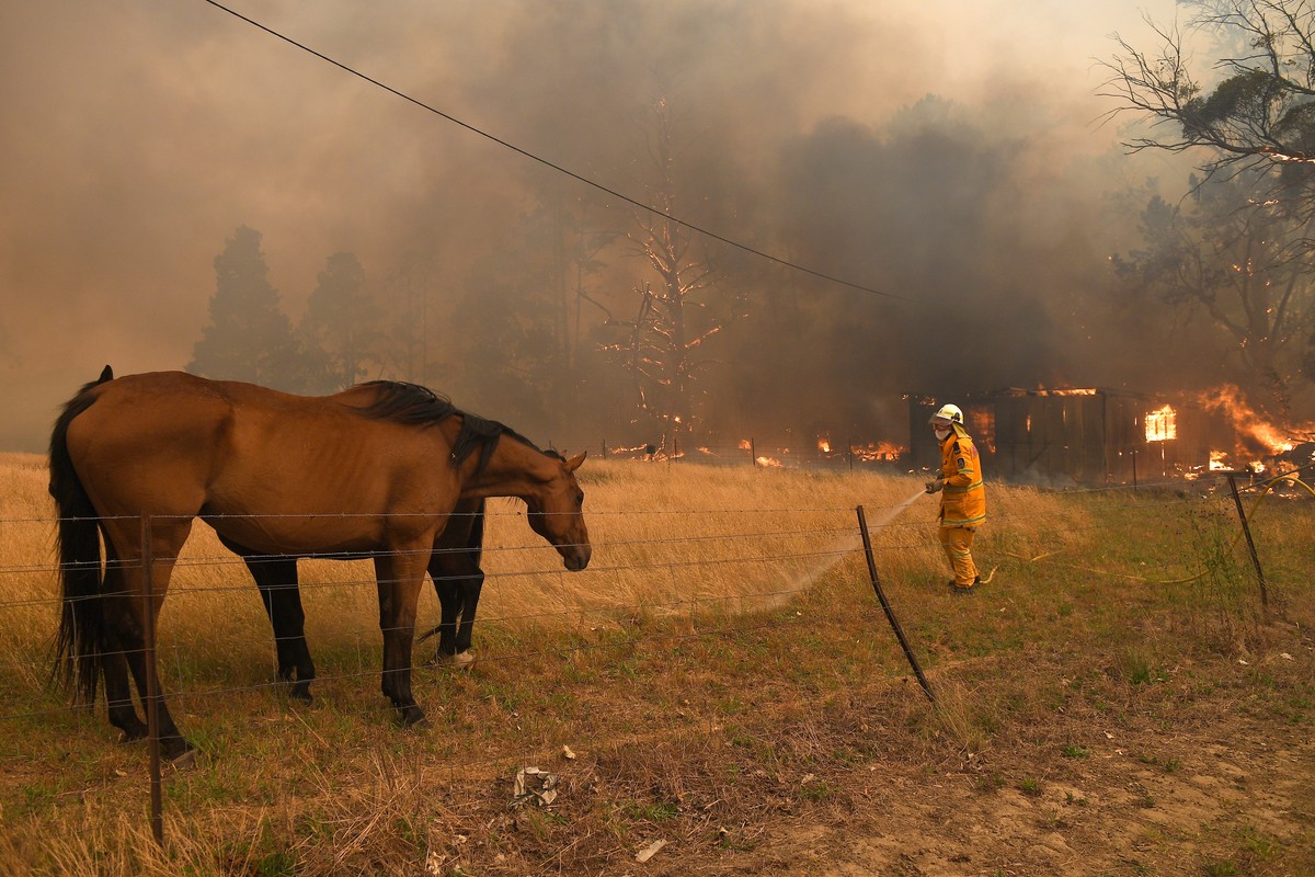 epa08084501 NSW Rural Fire Service crews fight the Gospers Mountain Fire as it impacts a structure at Bilpin, in the Blue Mountains, west of Sydney, New South Wales (NSW), Australia, 21 December 2019. ...
