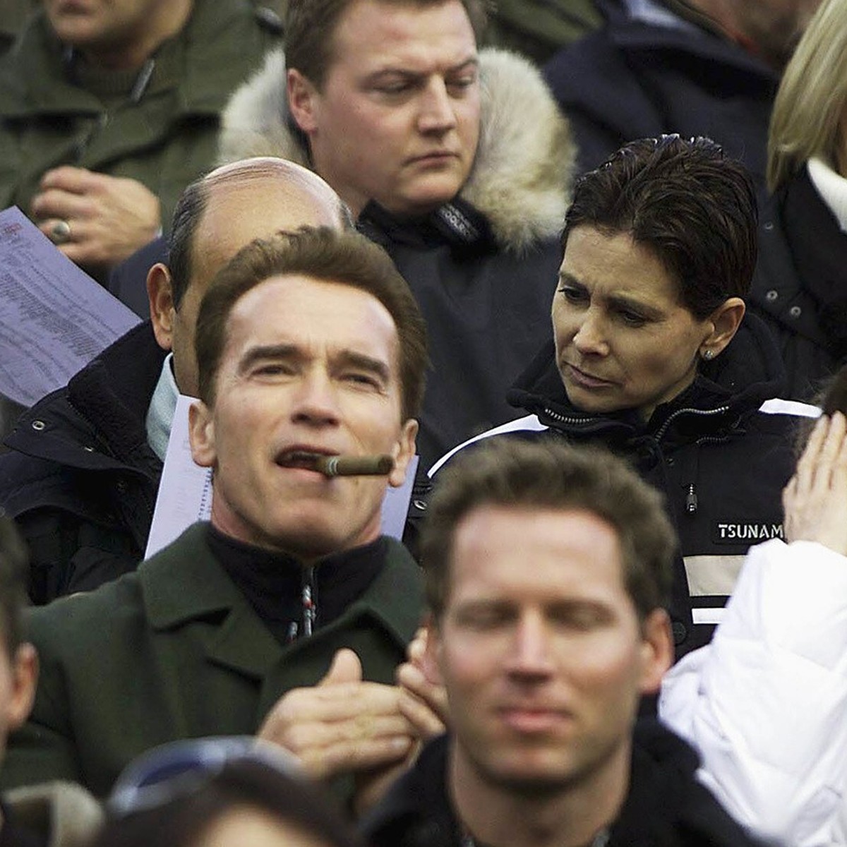 Austrian born actor Arnold Schwarzenegger, center, smokes a cigar as he and his wife Maria Shriver, left, watch the men's skiing World Cup downhill race in Kitzbuehel, Austria, on Saturday, Janua ...