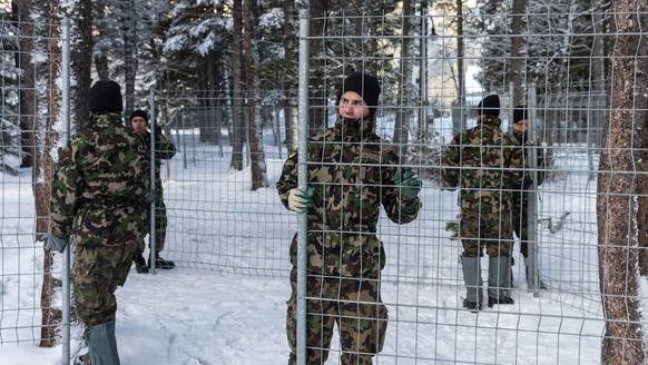 Angehoerige der Schweizer Armee montieren im Vorfeld des World Economic Forum, WEF, Abschrankungsgitter entlang eines Sicherungraums in Davos, am Montag, 6. Januar 2014. Der Einsatz der Armee zugunste ...