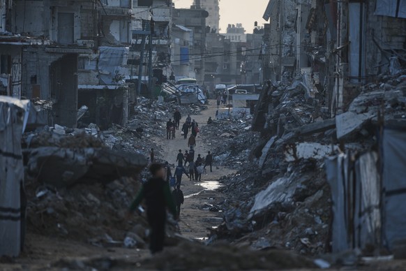 Palestinians walk amid buildings destroyed by Israeli air and ground operations in Gaza City Thursday, Jan. 15, 2026. (AP Photo/Jehad Alshrafi)
Israel Palestinians Gaza