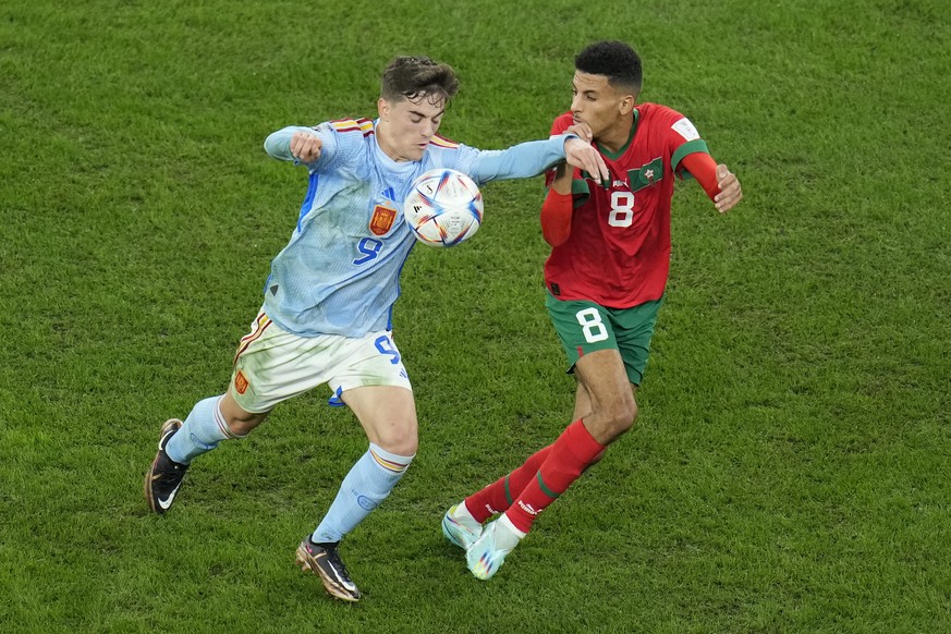 Spain&#039;s Gavi, left, fights for the ball with Morocco&#039;s Azzedine Ounahi during the World Cup round of 16 soccer match between Morocco and Spain, at the Education City Stadium in Al Rayyan, Qa ...