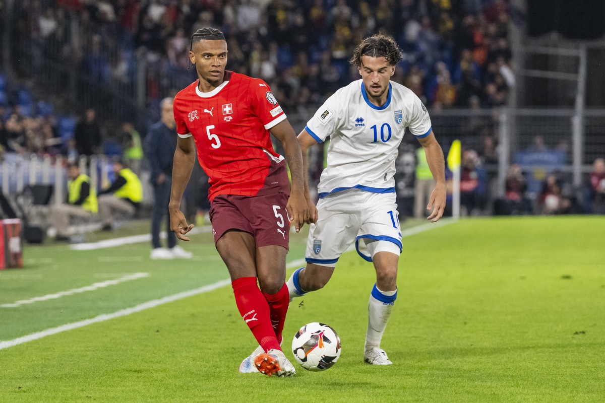 epa12355646 Switzerland's Manuel Akanji, left, plays the ball against Kosovo's Leon Avdullahu, during the FIFA 2026 World Cup Group B qualifying soccer match between Switzerland and Kosovo a ...
