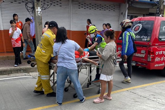 An injured is carried on a stretcher outside a outside a school where deaths and injuries were reported after a shooting in Thailand's Nonthaburi province, Friday, Aug. 7, 2026. (Por Tek Tueng No ...