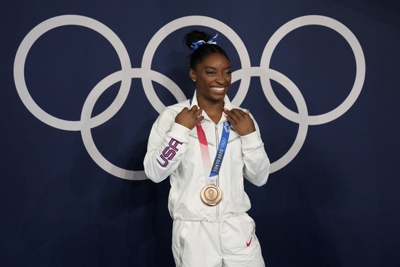 FILE - Simone Biles, of the United States, poses wearing her bronze medal from balance beam competition during artistic gymnastics at the 2020 Summer Olympics, Tuesday, Aug. 3, 2021, in Tokyo, Japan.  ...