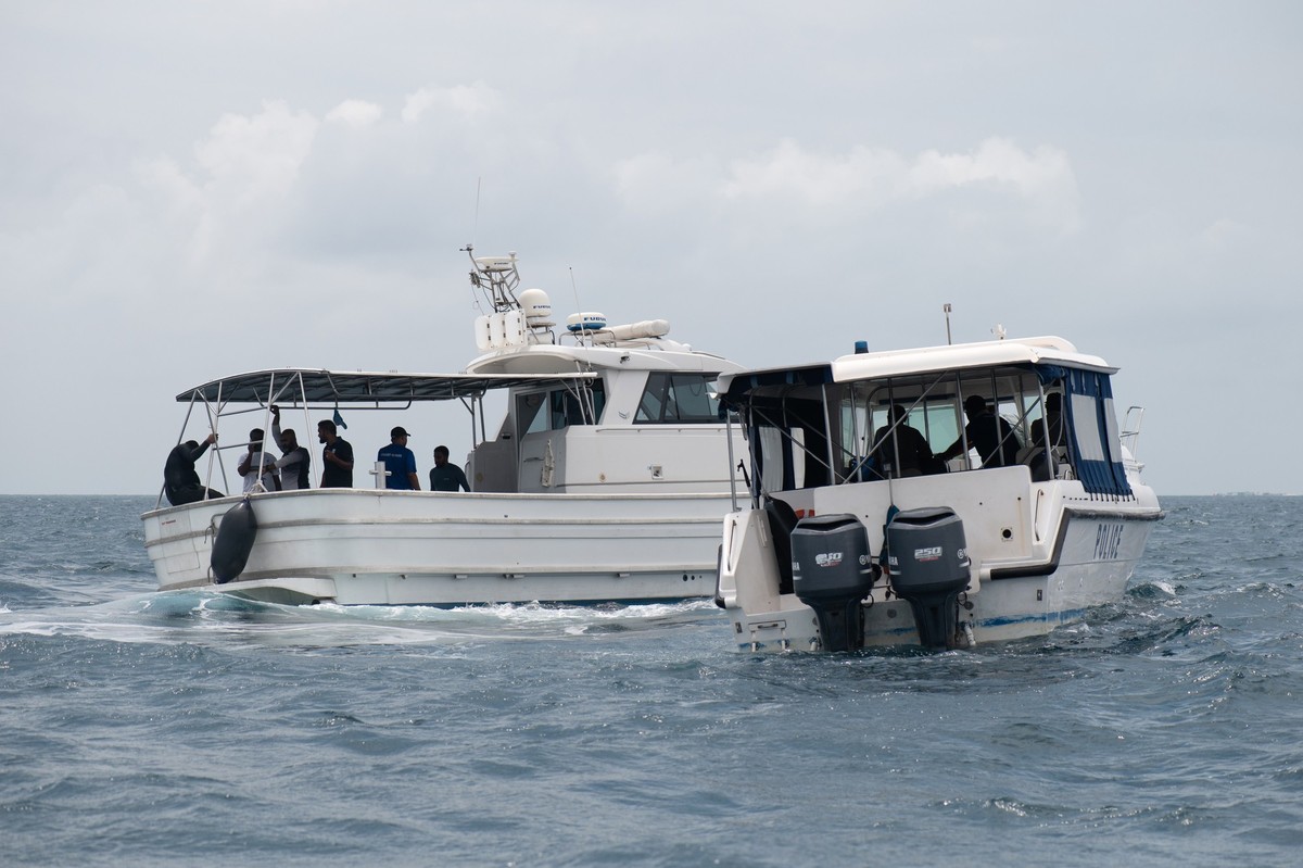 epa12964169 Members of the Maldives Marine Police and a police boat from the nearby island of Felidhoo during a search and recovery operation in the Vaavu Atoll, Maldives, 16 May 2026. The operation f ...