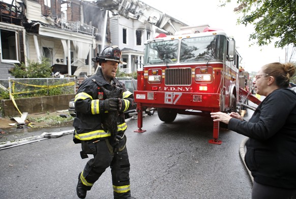 Ein Feuerwehrmann rettet die Katze einer Anwohnerin aus Staten Island aus einem brennenden Haus.