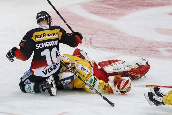 Biels Torhueter Jonas Hiller, rechts, liegt nach einem Zusammenprall mit Berns Tristan Scherwey, links, und Biels Robbie Earl, rechts, auf dem Eis, im siebten Eishockey Playoff-Halbfinalspiel der Nati ...