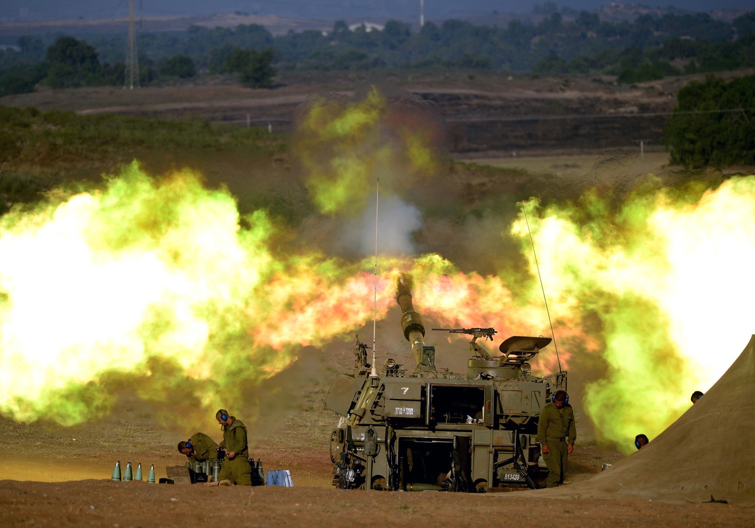 epaselect epa04331561 An Israeli artillery cannon fires from southern Israel into the Gaza Strip, early 26 July 2014, just before the start of the 12 hour humanitarian aid ceasefire. The Israeli milit ...