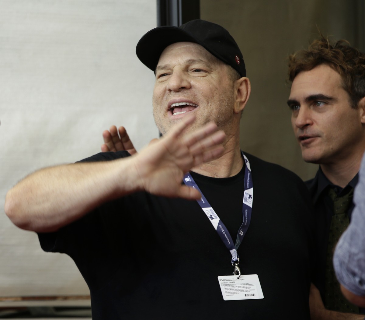Film mogul Harvey Weinstein gestures to photographers, left, as actor Joaquin Phoenix speaks to him after the photo call for the film 'The Master' at the 69th edition of the Venice Film Fest ...