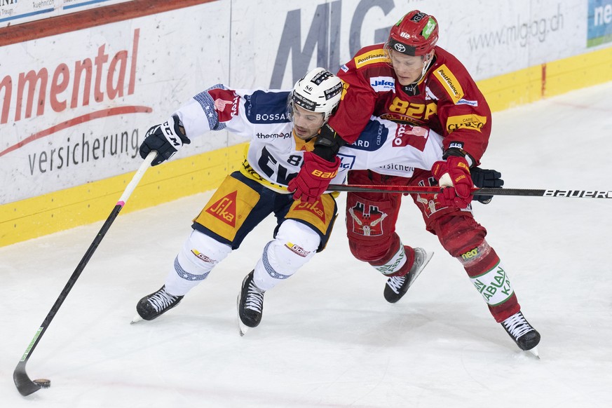 Tigers Harry Pesonen, rechts, im Kampf um den Puck gegen Zugs Marco Mueller, links, waehrend dem Qualifikationsspiel der Eishockey National League zwischen den SCL Tigers und dem EV Zug, am Samstag, 4 ...