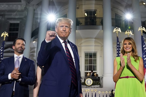 From left, Donald Trump Jr., President Donald Trump and first lady Melania Trump stand on the South Lawn of the White House on the fourth day of the Republican National Convention, Thursday, Aug. 27,  ...