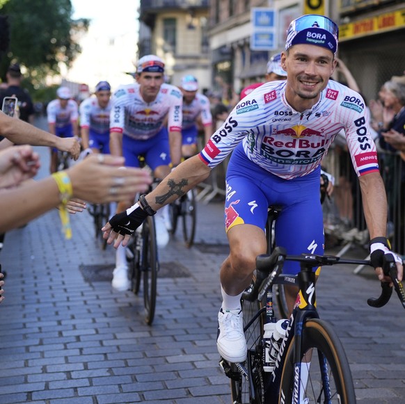 Slovenia&#039;s Primoz Roglic and his Red Bull Bora Hans Grohe teammates greet fans during the team presentation two days ahead of the start of the Tour de France Cycling race in Lille, France, Thursd ...