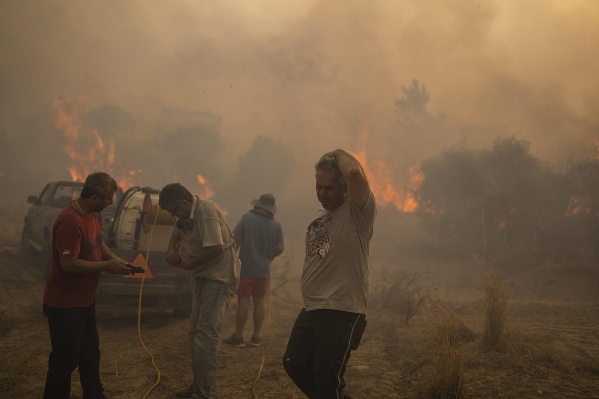 Locals try to extinguish a wildfire burning in Gennadi village, on the Aegean Sea island of Rhodes, southeastern Greece, on July 25, 2023. (AP Photo/Petros Giannakouris)