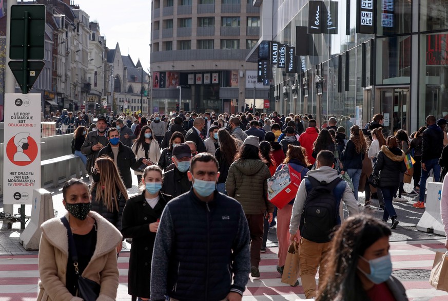 epa08788712 People queue in front of so-called non-essential stores 2 days before new measures against COVID-19 come into force in Rue Neuve, the main shopping street in Brussels, Belgium, 31 October  ...
