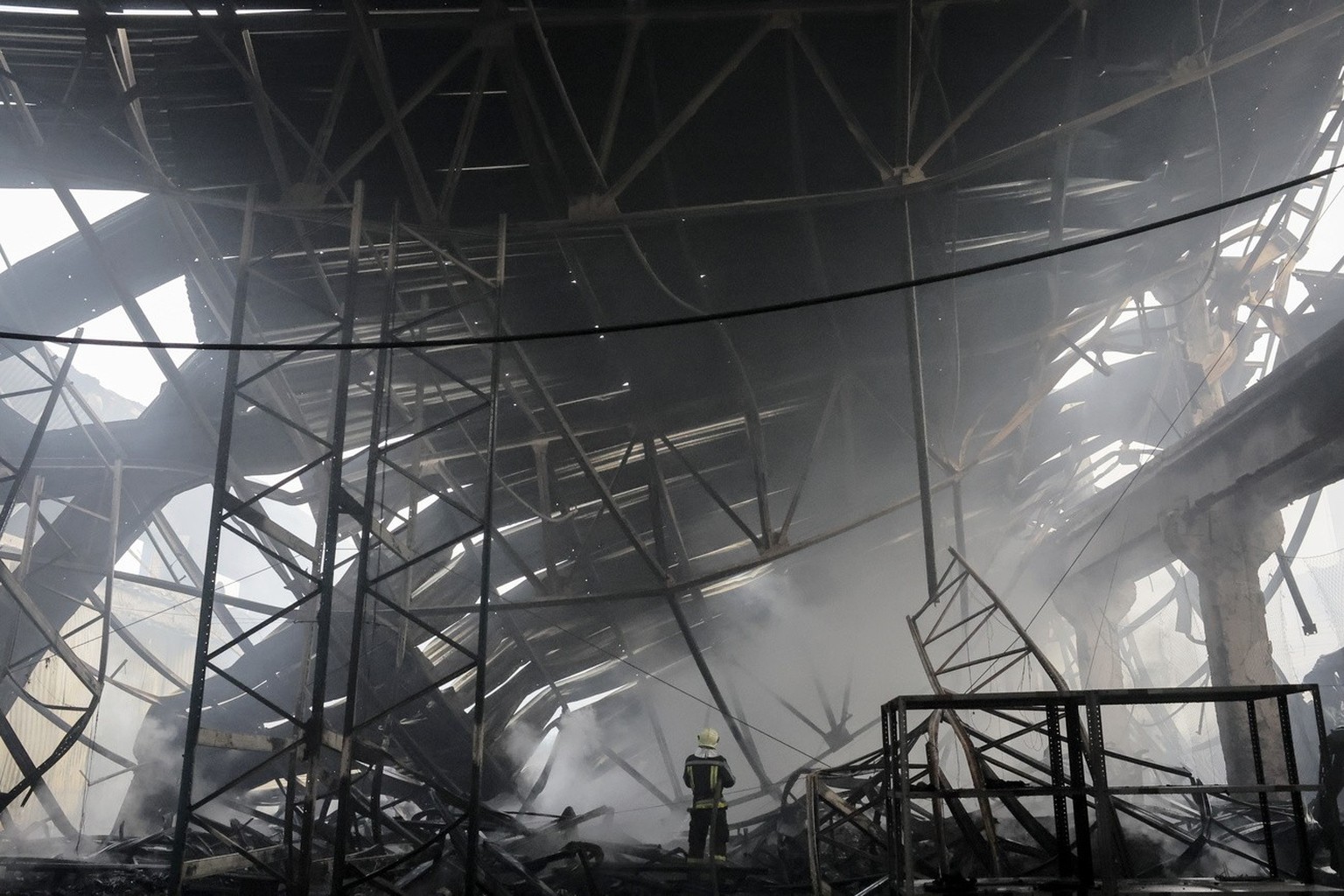 epa11047957 Ukrainian rescuers work at the site of a rocket attack on a civilian warehouse in Kyiv (Kiev), Ukraine, 29 December 2023, amid the Russian invasion. At least 16 people have died and dozens ...