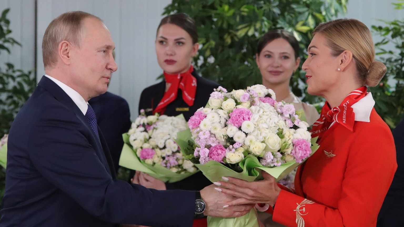 Russian President Vladimir Putin congratulates representatives of the Russian Airlines flight crew on the upcoming International Women's Day during his visit to the Aeroflot Aviation School outside M...