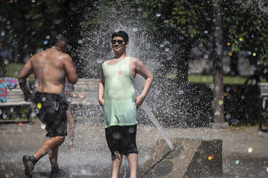 While Portland, Ore., reached a record temperature of over 110 degrees Sunday, June 27, 2021, people gathered at Salmon Street Springs water fountain in Portland to cool off. (Mark Graves/The Oregonia ...