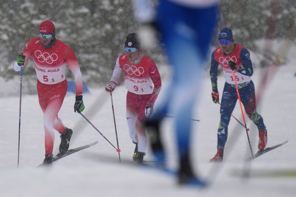 From left, Dario Cologna, of Switzerland, Ryo Hirose, of Japan, and Miha Simenc, of Slovenia, compete during the men&#039;s 4 x 10km relay cross-country skiing competition at the 2022 Winter Olympics, ...