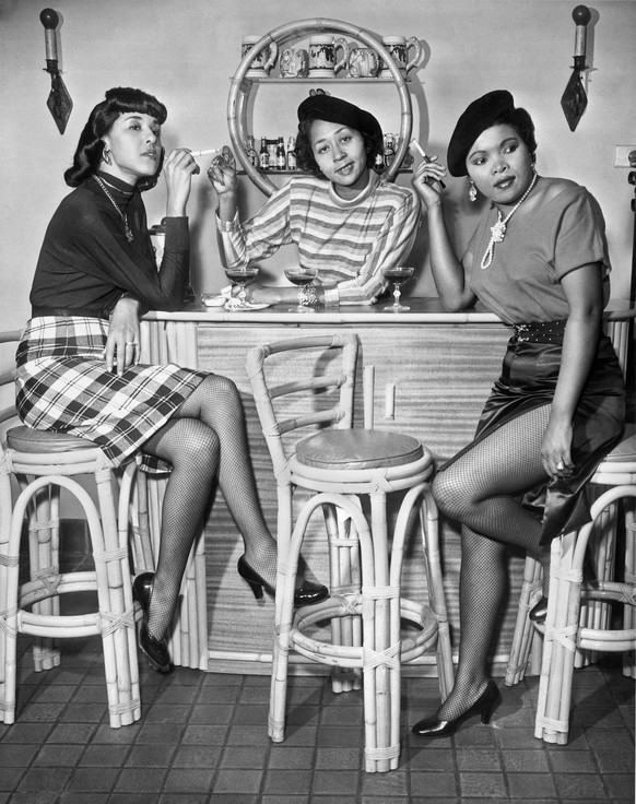 Los Angeles, California: c. 1960. Three stylish African American women sitting with their drinks and cigarettes PUBLICATIONxINxGERxSUIxAUTxHUNxONLY 990_16_3-Food-Bev-AC_5HR