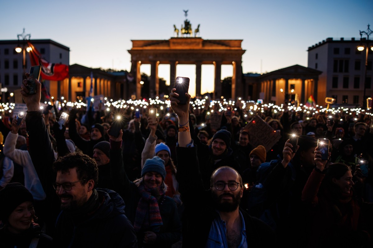 epa12465266 Participants shine with the flashlights of their mobile phones during a rally at the Brandenburg Gate landmark in Berlin, Germany, 19 October 2025. The rally was held under the motto ' ...