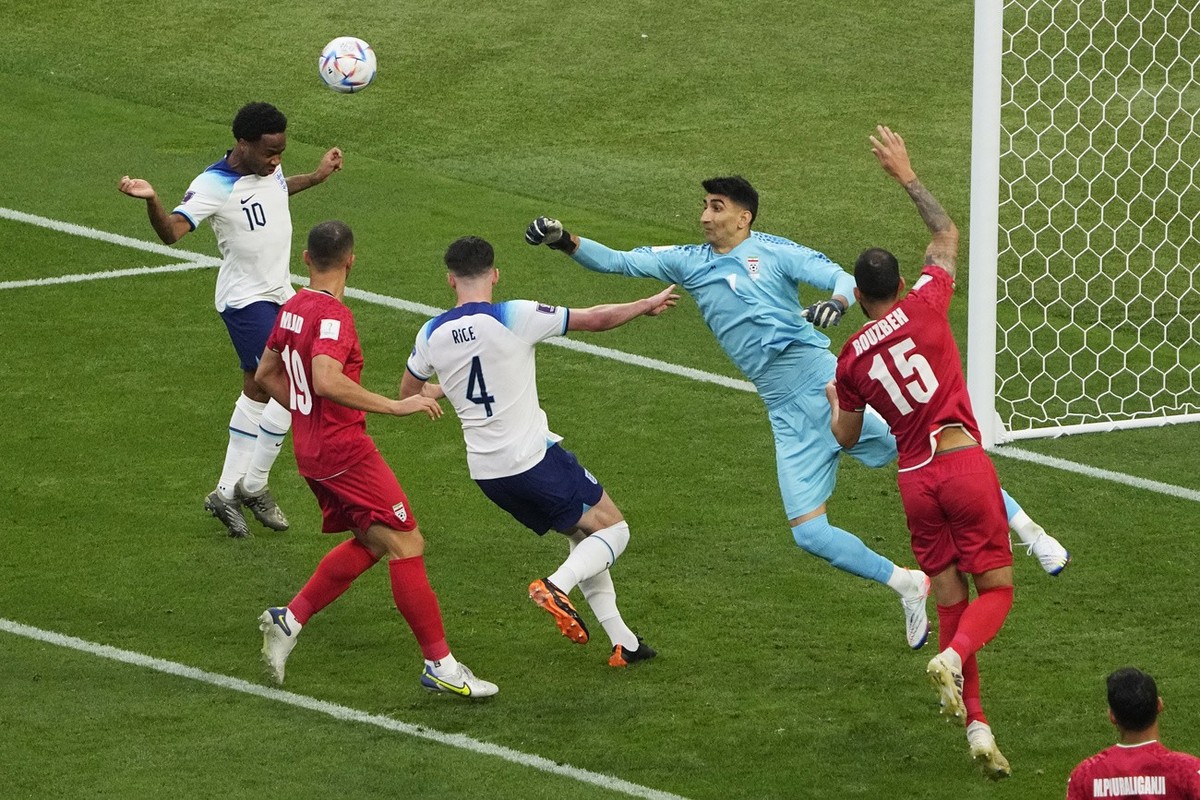 Iran's goalkeeper Alireza Beiranvand, second from right, clears the ball before colliding with Iran's Majid Hosseini, second from left, the World Cup group B soccer match between England and ...