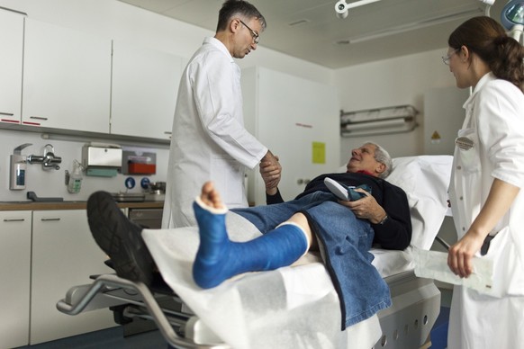 A man speaks to a doctor at &quot;Ospidale Val Muestair&quot; hospital after having his broken lower leg plastered, pictured on February 17, 2012, in Santa Maria in the canton of Grisons, Switzerland. ...