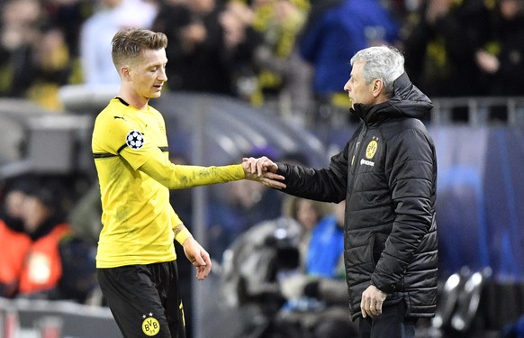 Dortmund midfielder Marco Reus shakes hands with Dortmund coach Lucien Favre after being substituted during the Champions League round of 16, 2nd leg, soccer match between Borussia Dortmund and Totten ...