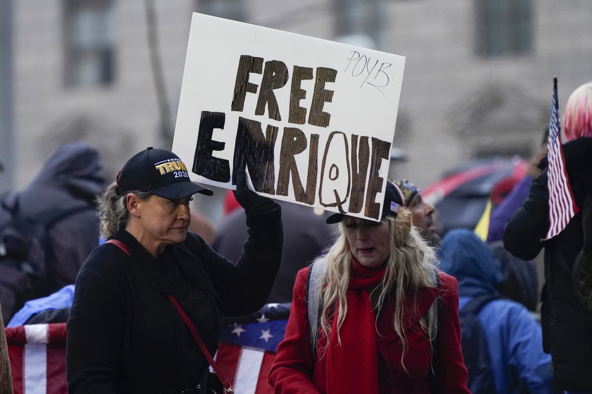People hold a sign reading 'Free Enrique' in reference to Proud Boys leader Henry "Enrique" Tarrio, who was arrested on Monday when he arrived back in the District, as they attend  ...