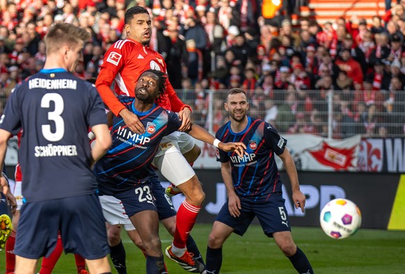 24.02.2024, Berlin: Fu�ball: Bundesliga, 1. FC Union Berlin - 1. FC Heidenheim, 23. Spieltag, An der Alten F�rsterei. Omar Traore (M unten) von Heidenheim in Aktion gegen Berlins Danilho Doekhi (M obe ...