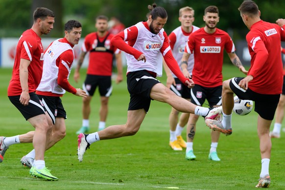 epa09248307 Polish national soccer team players Grzegorz Krychowiak (C), Jakub Swierczok (L) and Robert Lewandowski (2L) in action during a training session in Opalenica, Poland, 04 June 2021. Poland ...