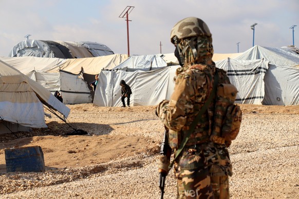 epa11108391 A fighter of Syria Democratic Forces (SDF) stands guard during a search operation inside the al-Hol camp for refugees in al-Hasakah governorate, northeastern Syria, 27 January 2024. The SD ...