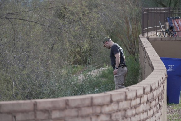 An investigator walks around homes in the neighborhood where Annie Guthrie, whose mother Nancy Guthrie has been missing for more than a week, lives just outside Tucson, Ariz., on Tuesday, Feb. 10, 202 ...
