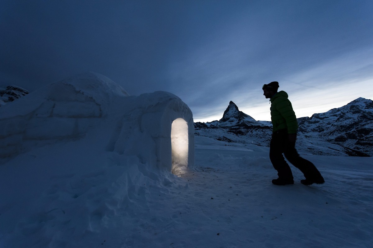 epa05132803 A man enters in a Igloo at the 'Igloo village' (Iglu Dorf) in front of the famous Matterhorn mountain in Zermatt, Switzerland, early 29 January 2016. The hotel-igloo village made ...