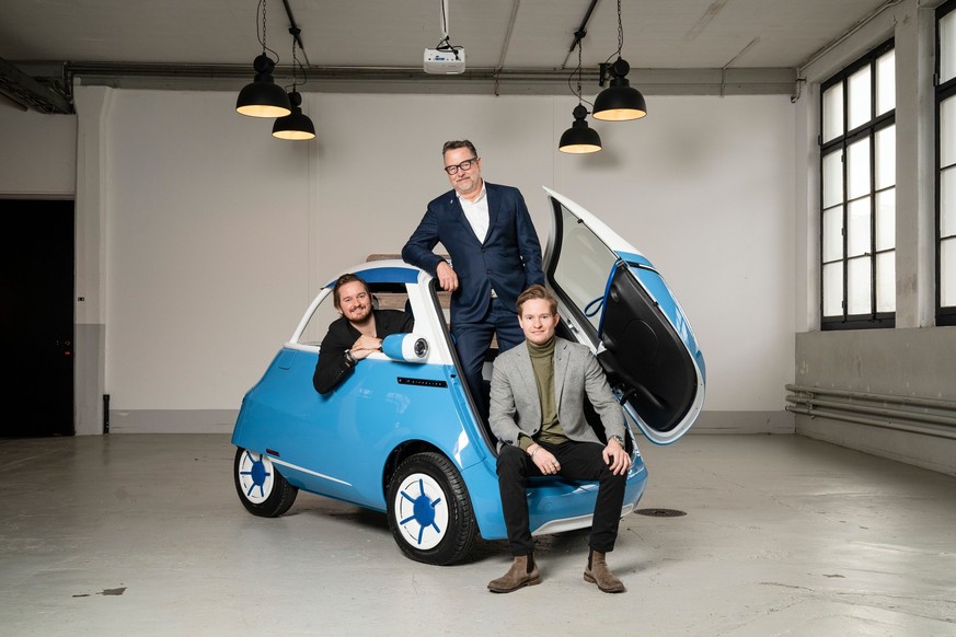 Brothers Oliver Ouboter (sitting in car) and Merlin Ouboter together with their father, kickboard inventor Wim Ouboter.