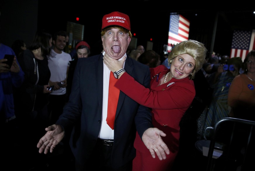 Supporters of Democratic U.S. presidential candidate Hillary Clinton, who came to her rally in costume as Republican presidential candidate Donald Trump (L) and as Mrs. Clinton (R), clown around as th ...