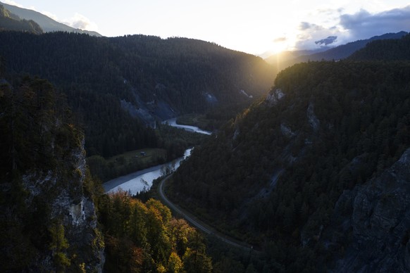 Die letzten Sonnenstrahlen scheinen durch die Rheinschlucht auf herbstlich verfaerbte Baeume, am Dienstag, 3. Oktober 2017, bei Versam. (KEYSTONE/Gian Ehrenzeller)