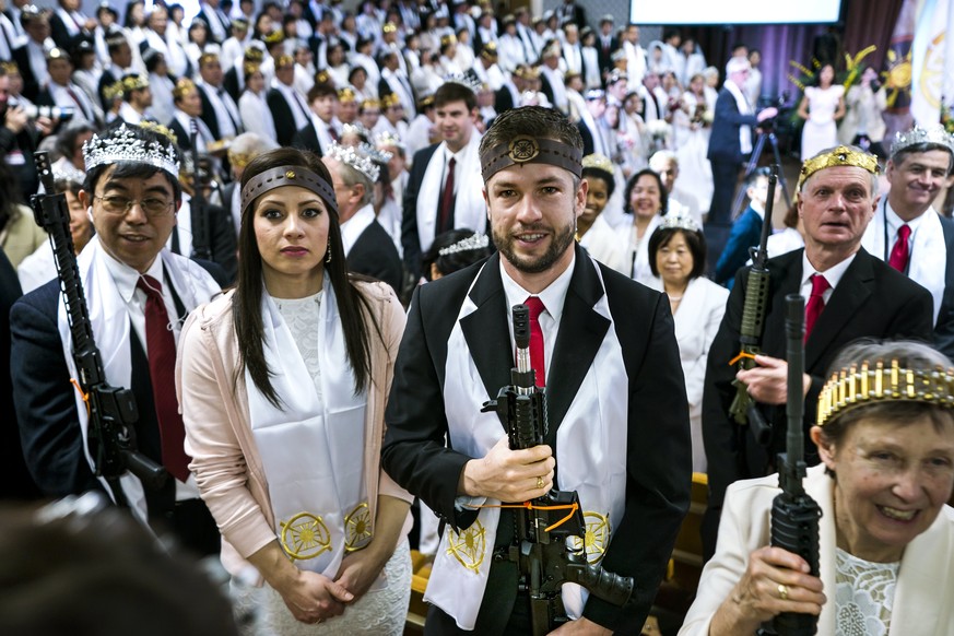 epa06570912 Parishioners with the Sanctuary Church hold onto their AR-15s, which churchgoers were encouraged to bring to a blessing ceremony to rededicate their marriages, at the World Peace and Unifi ...