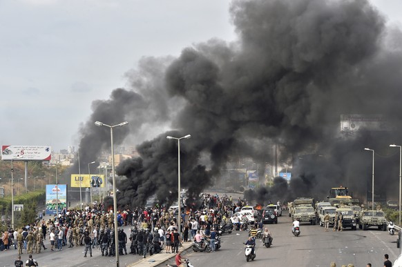 epa07930486 Protesters burn tires as they block the highway heading to the Beirut international airport during a protest in Beirut, Lebanon, 18 October 2019. Protesters, mainly civil activists, starte ...