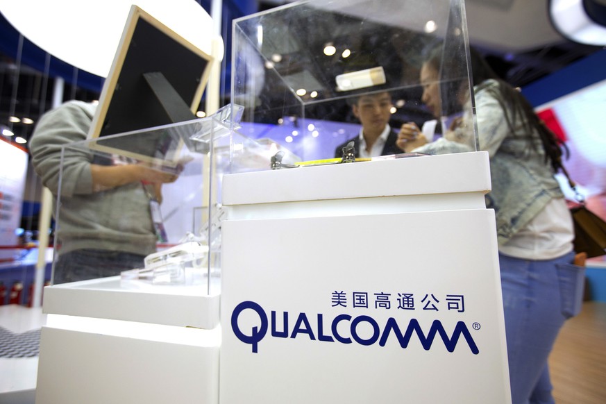 FILE - In this Thursday, April 27, 2017, file photo, visitors look at a display booth for Qualcomm at the Global Mobile Internet Conference (GMIC) in Beijing. Broadcom is boosting its buyout offer for ...