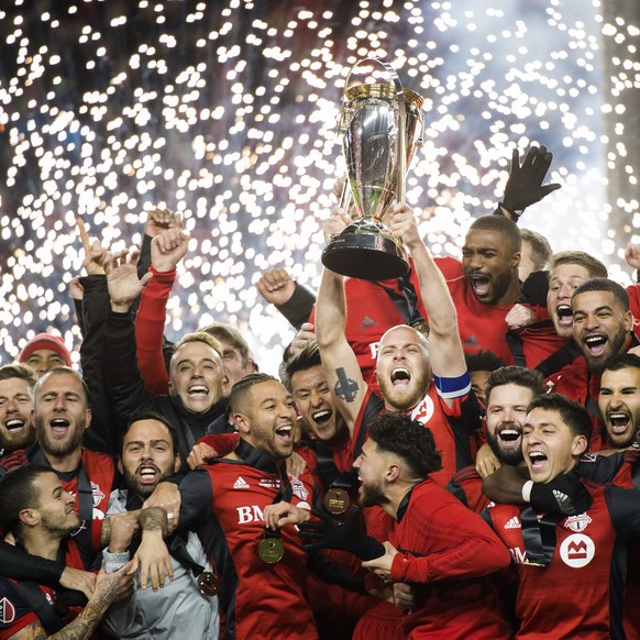 Toronto FC captain Michael Bradley hoists the trophy as the team celebrates its win over the Seattle Sounders in the MLS Cup final in Toronto, Saturday, Dec. 9, 2017. (Nathan Denette/The Canadian Pres ...