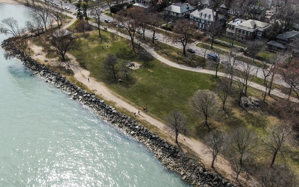 epa08342078 An aerial photo made with a drone shows people walking on a path along Lake Michigan in Evanston, Illinois, USA, 03 April 2020. Illinois remains under a stay at home order issued by Illino ...