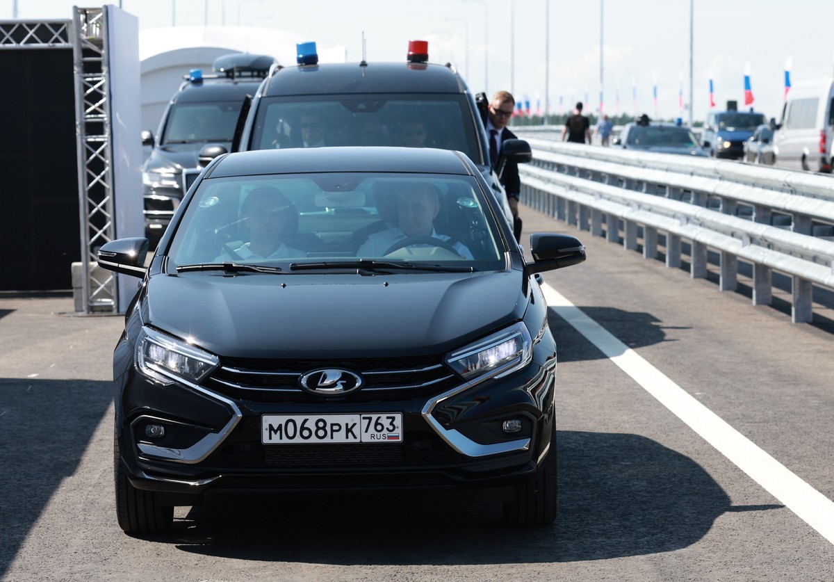 Russian President Vladimir Putin, right, drives a Lada Aura car, front, as he arrives to attend a ceremony to open the Northern Tver Bypass on the M-11 Neva highway and the Togliatti Bypass in Samara  ...