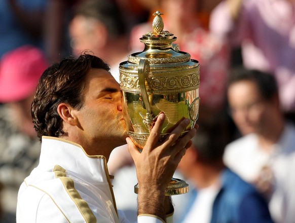 epa01785052 epa01784244 Roger Federer of Switzerland kisses the championship trophy after his victory over Andy Roddick of the US in their men&#039;s singles final match for the Wimbledon Championship ...