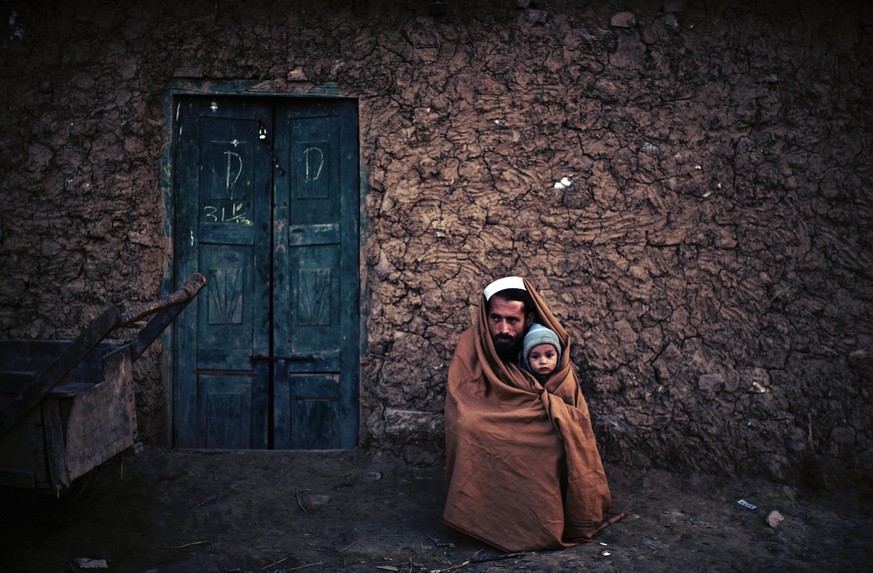 Ein Pakistani mit seinem Sohn vor seinem Haus in einem Aussenbezirk von Islamabad.