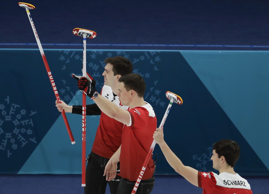 Switzerland&#039;s skip Peter de Cruz, left, Benoit Schwarz, right, and Claudio Paetz celebrate winning a men&#039;s curling match against Canada at the 2018 Winter Olympics in Gangneung, South Korea, ...