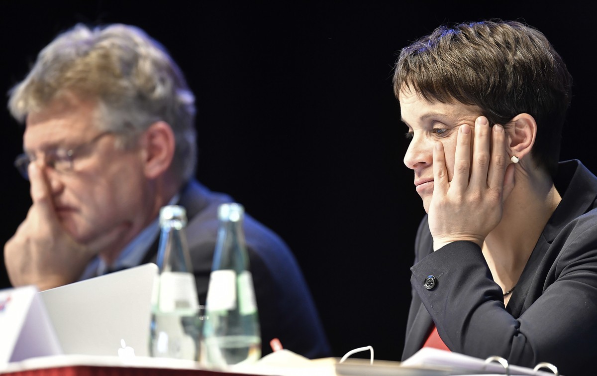 Party leaders Frauke Petry, right, and Joerg Meuthen, left, sit on the podium at the party convention of Germany's nationalist party AfD (Alternative for Germany) in Cologne, Germany, Saturday, A ...