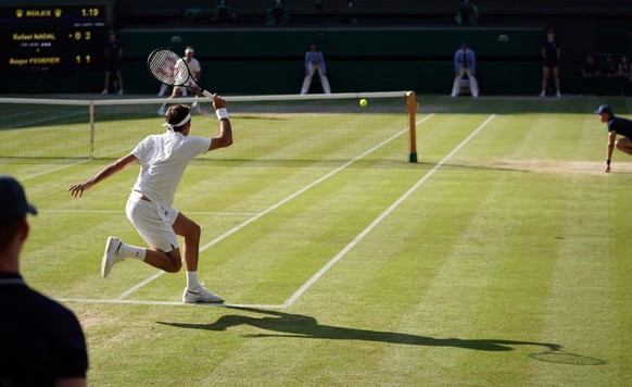 epa07712956 Roger Federer of Switzerland returns to Rafael Nadal of Spain in their semi final match during the Wimbledon Championships at the All England Lawn Tennis Club, in London, Britain, 12 July  ...