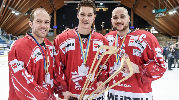 Team Canadas players Andrew Ebbett, Mason Raymond and Maxim Noreau celebrate with the trophy after winnig the final game between Team Canada and Team Suisse at the 91th Spengler Cup ice hockey tournam ...