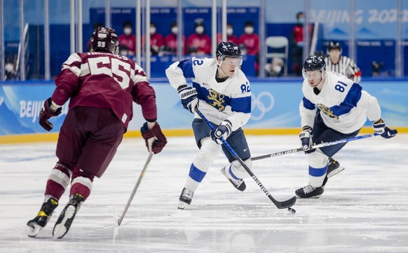 epa09747459 Roberts Mamcics (L) of the Latvia in action against Harri Pesonen (C) of Finland during the Men's Ice Hockey preliminary round match between Latvia and Finland at the Beijing 2022 Oly ...