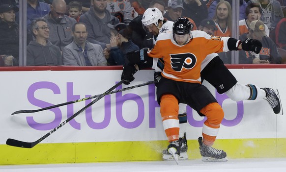 Philadelphia Flyers&#039; Michael Raffl (12) collides with San Jose Sharks&#039; Brenden Dillon (4) during the first period of an NHL hockey game, Tuesday, Nov. 28, 2017, in Philadelphia. (AP Photo/Ma ...
